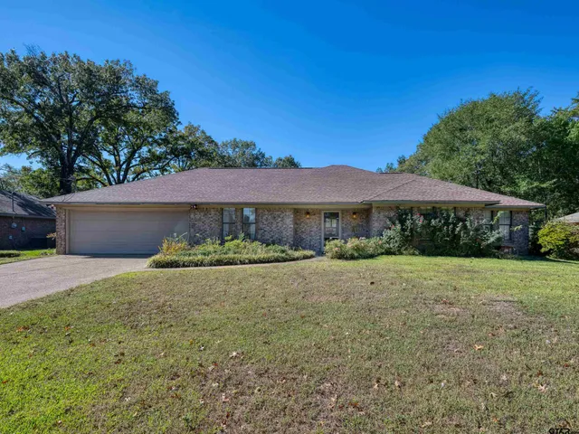 a view of a house with a yard and large tree
