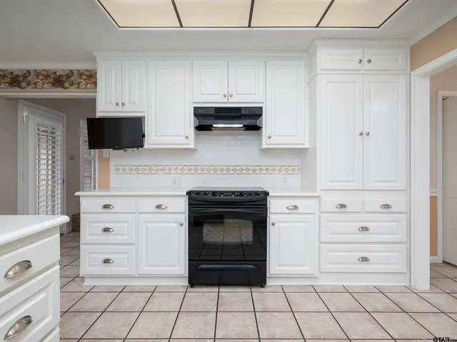 a kitchen with white cabinets and appliances