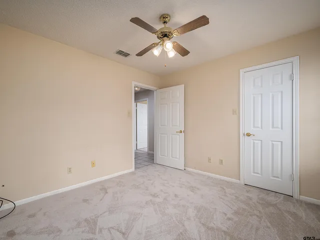 an empty room with closet and fan