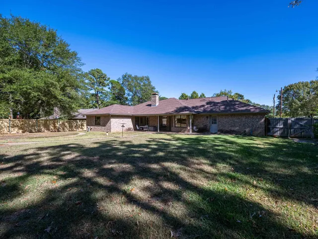 a view of a big house with a big yard and large tree