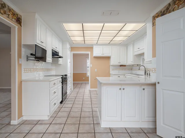 a kitchen with a sink window and stainless steel appliances