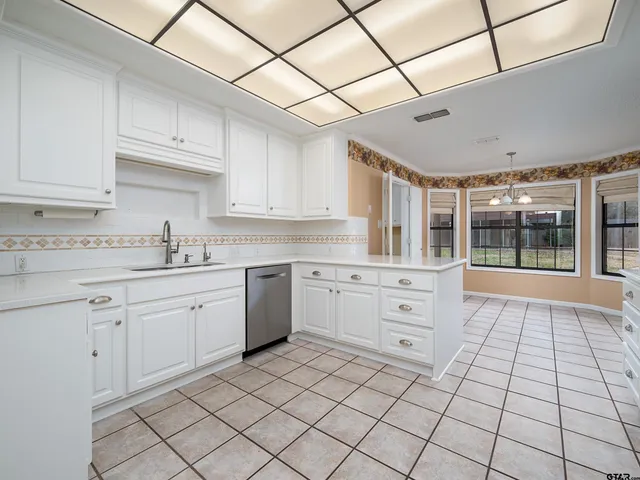 a kitchen with white cabinets and appliances