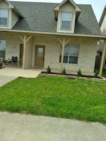 a front view of a house with a garden and yard