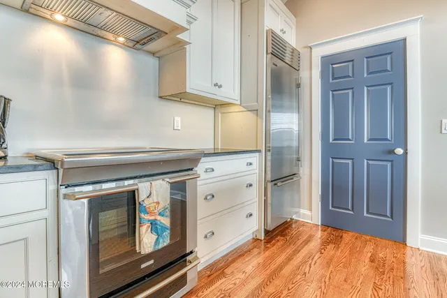 a kitchen with cabinets appliances and a wooden floor