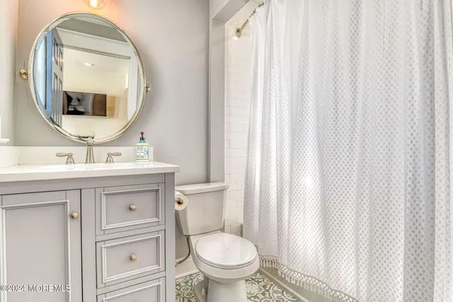 a bathroom with a toilet a sink and a mirror