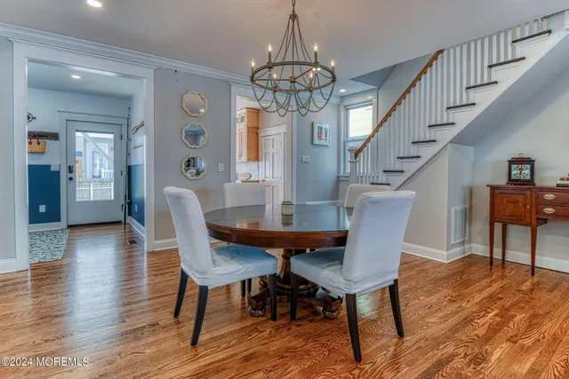 a view of a dining room with furniture a chandelier and wooden floor