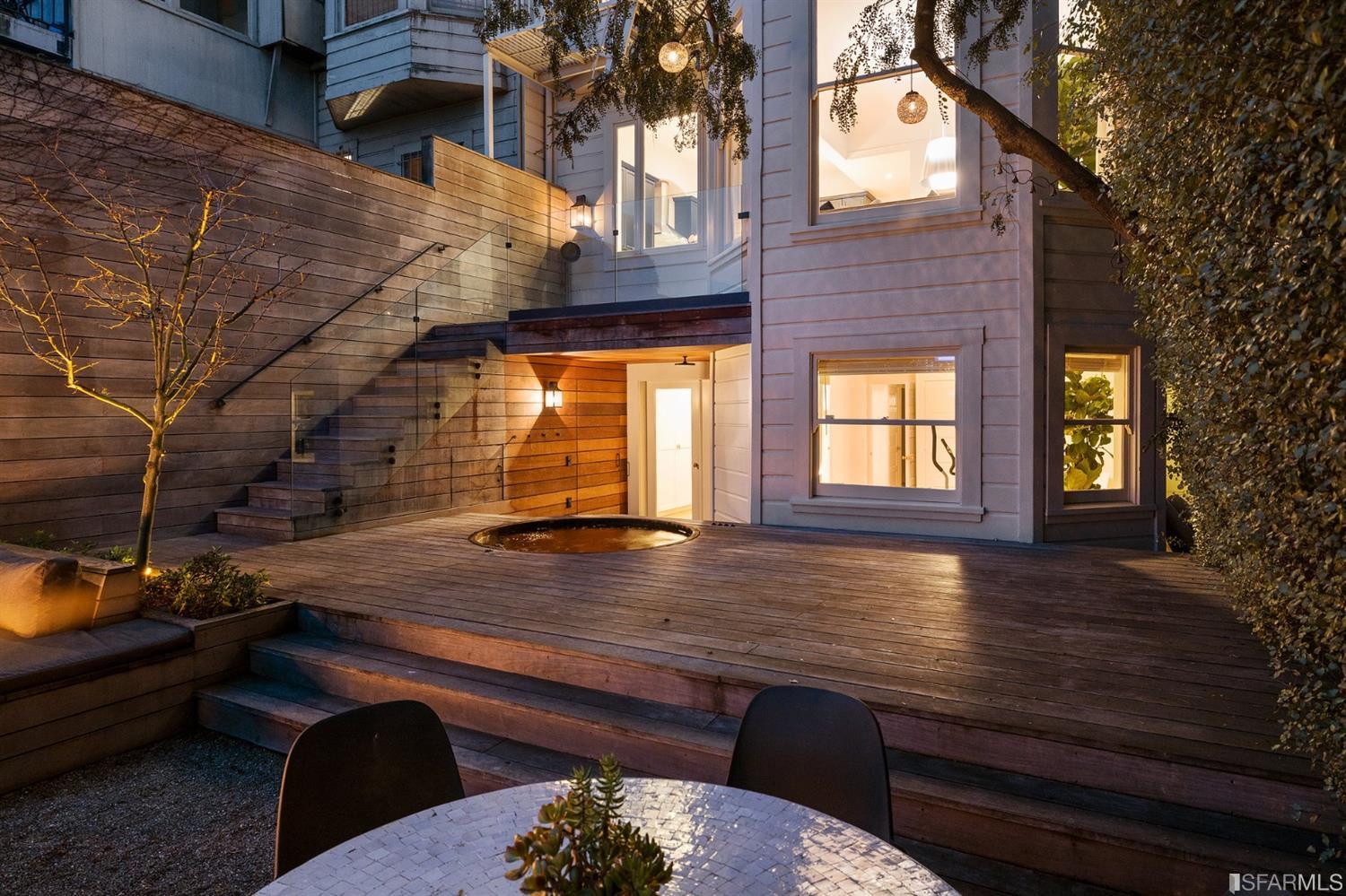 818 Steiner Street San Francisco, CA 94117 - Photo 66 of 74 Lower level is complete with a separate au pair or guest quarters that includes a bedroom/lounge and a full-bath which can be accessed separately though the home's side entrance. Down the hall are a home gym & full-bathroom, a wine room, spacious laundry and utility areas, and a room with built-in storage that leads to the outdoor spa area with rain shower and cedar hot tub. There's never been a better yard for entertaining; built-in seating, a roaring fire pit, and a concrete slide in its lower-level turf-lawn play space. This home offers a lifestyle surrounded by the beauty of Alamo Square Park, the vibrancy of Hayes Valley and Divisadero Corridor, and a clear connection to San Francisco's downtown and beyond.