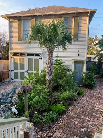 a front view of a house with a yard and potted plants