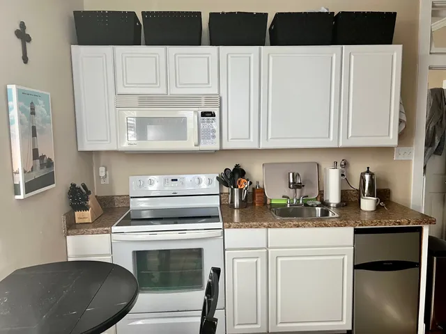 a kitchen with white cabinets and appliances