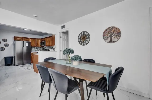 a view of a dining room with furniture and kitchen view