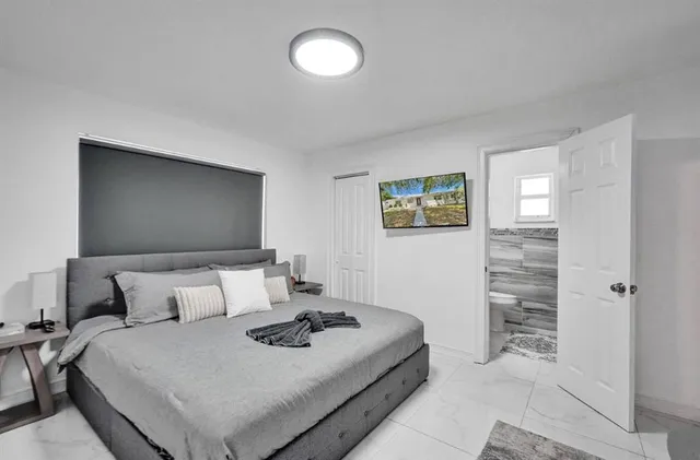 a bedroom with a bed and a flat screen tv