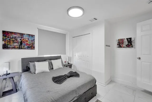 a bedroom with a bed and painting on the wall