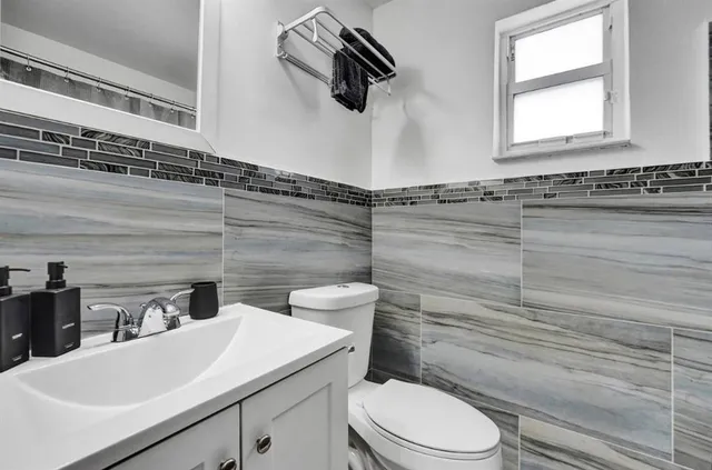 a bathroom with a granite countertop toilet sink and mirror