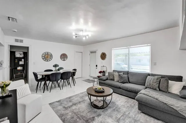 a living room with furniture a clock and a window