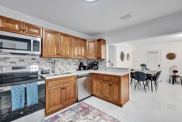 a kitchen with cabinets appliances and a sink