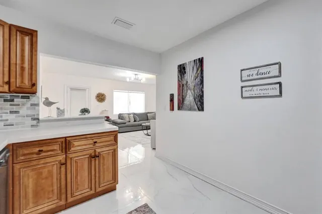 a kitchen with white cabinets and sink