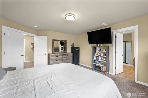 a large bedroom with a bed and a flat screen tv
