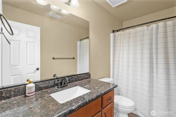 a bathroom with a granite countertop sink and a mirror