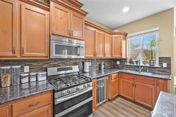 a kitchen with stainless steel appliances granite countertop a sink stove and cabinets