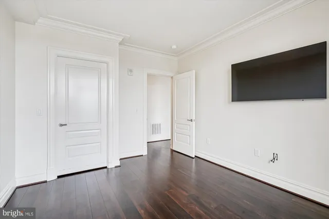 a view of a livingroom with wooden floor and a flat screen tv