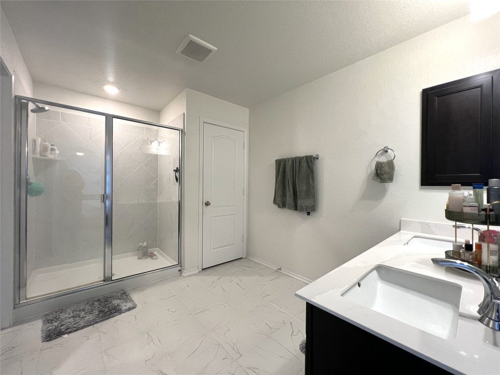 14313 James Buchanan Street Manor, TX 78653 - Photo 12 of 19 a bathroom with a sink a mirror and shower