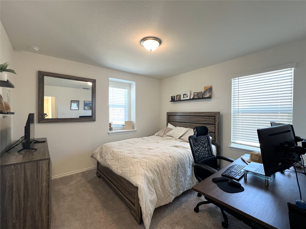 14313 James Buchanan Street Manor, TX 78653 - Photo 16 of 19 a bedroom with a bed and a table