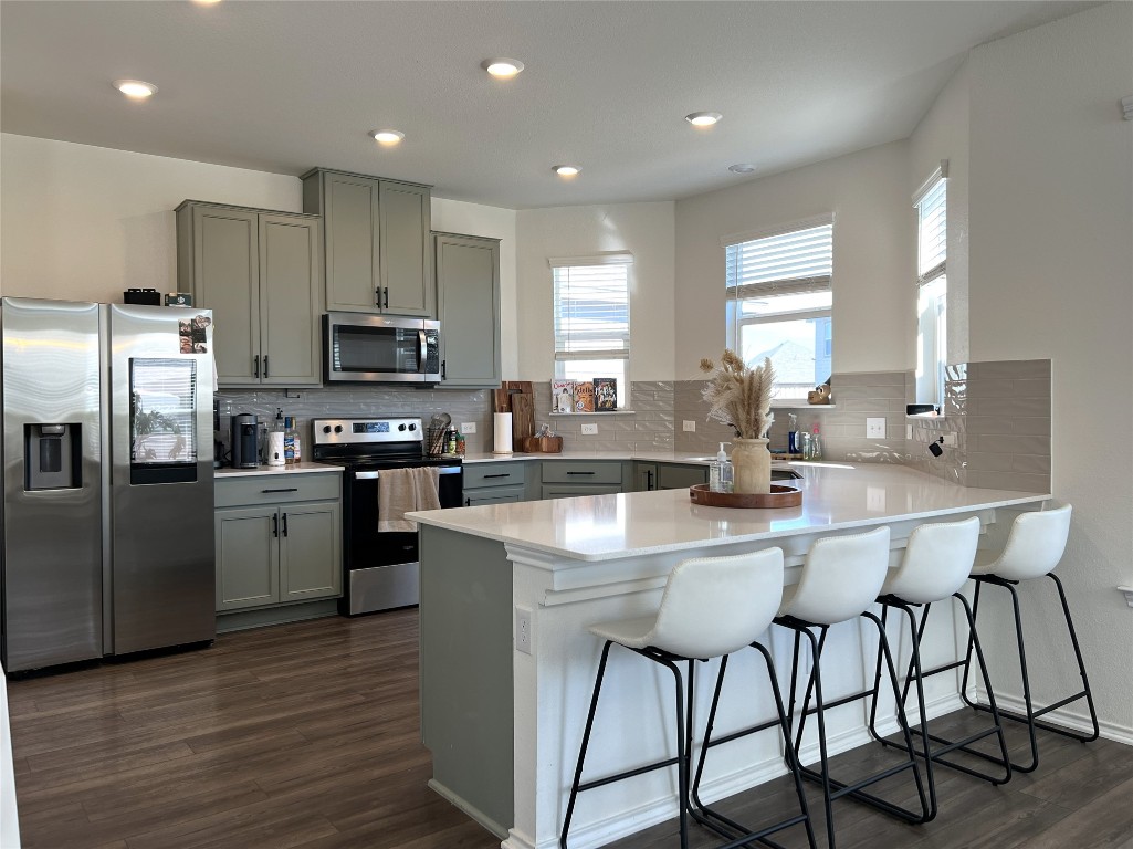 14313 James Buchanan Street Manor, TX 78653 - Photo 5 of 19 a kitchen with stainless steel appliances granite countertop a table chairs sink refrigerator and microwave