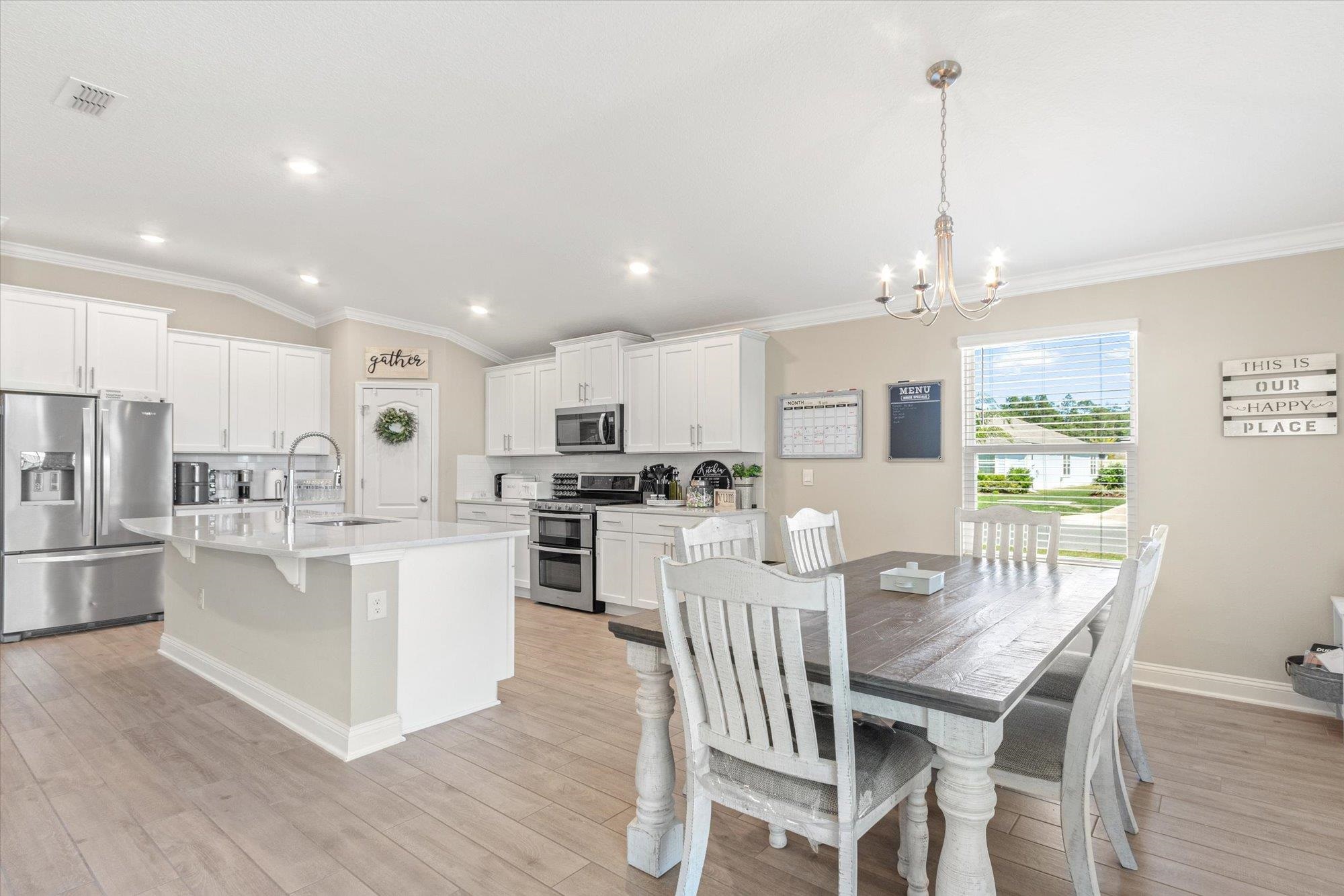 23 Alagon Way Street St. Augustine, FL 32084 - Photo 8 of 51 a kitchen with stainless steel appliances kitchen island granite countertop a table chairs and a refrigerator