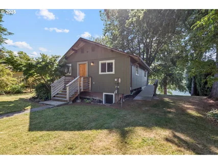 a view of a yard in front of a house with large trees