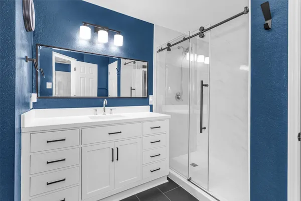 a bathroom with a double vanity sink mirror and shower