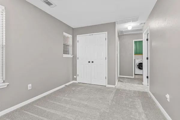 an empty room with closet and a chandelier fan