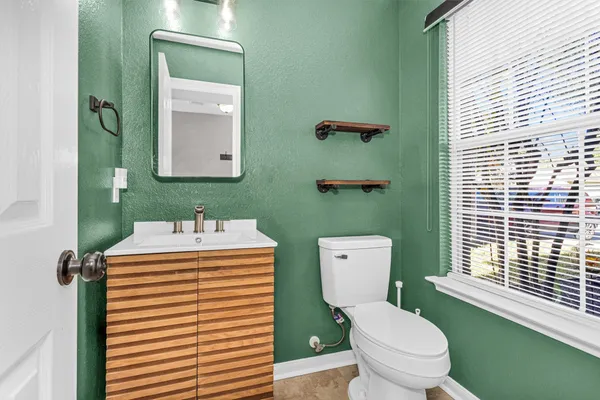 a bathroom with a toilet a sink and mirror