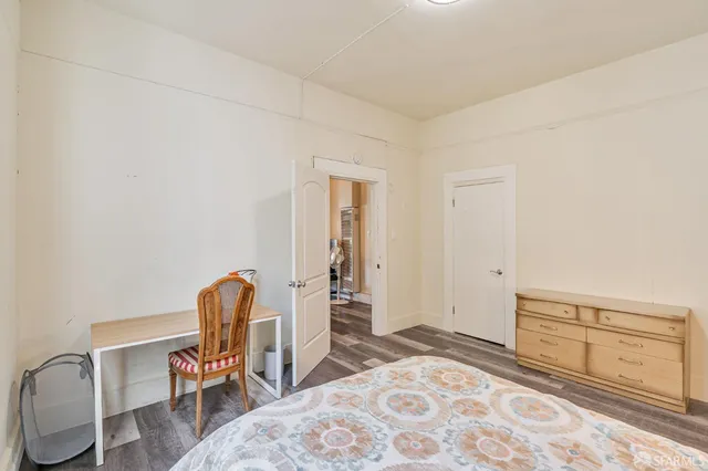 a bedroom with a chair and a dresser in it