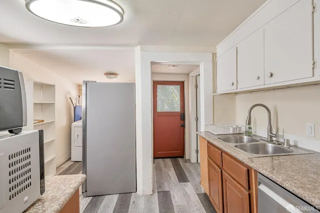 a kitchen with stainless steel appliances granite countertop a sink refrigerator and cabinets