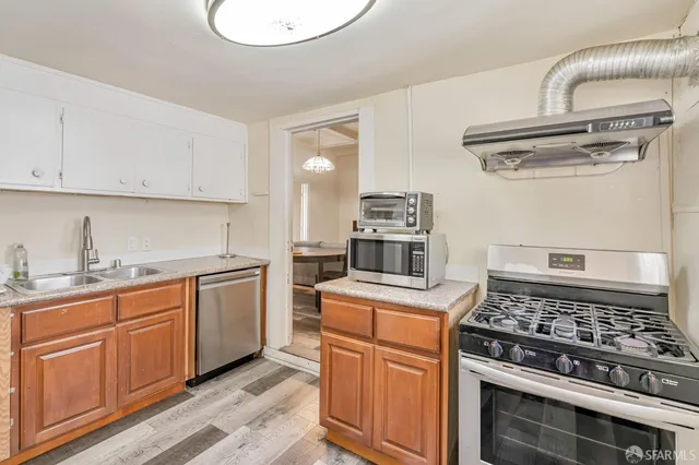 a kitchen with stainless steel appliances granite countertop a stove and a sink