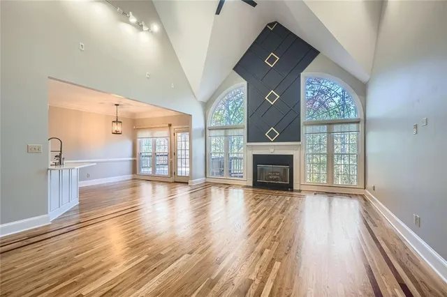 a view of empty room with wooden floor and fireplace