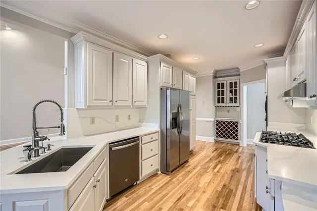 a kitchen with a sink stainless steel appliances and cabinets
