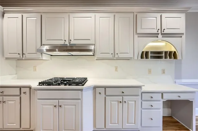a kitchen with white cabinets and appliances