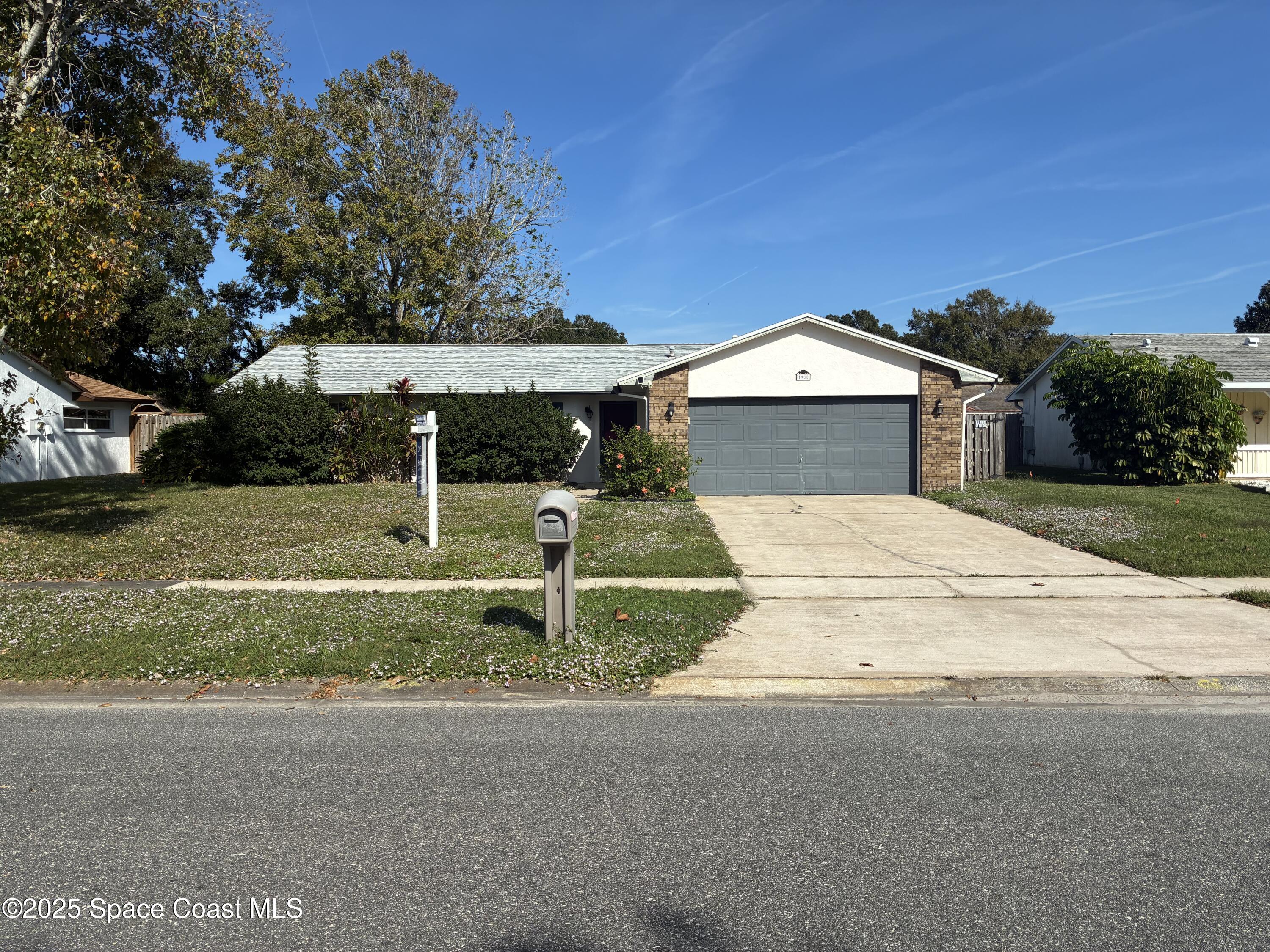 a view of a house with a yard and large tree