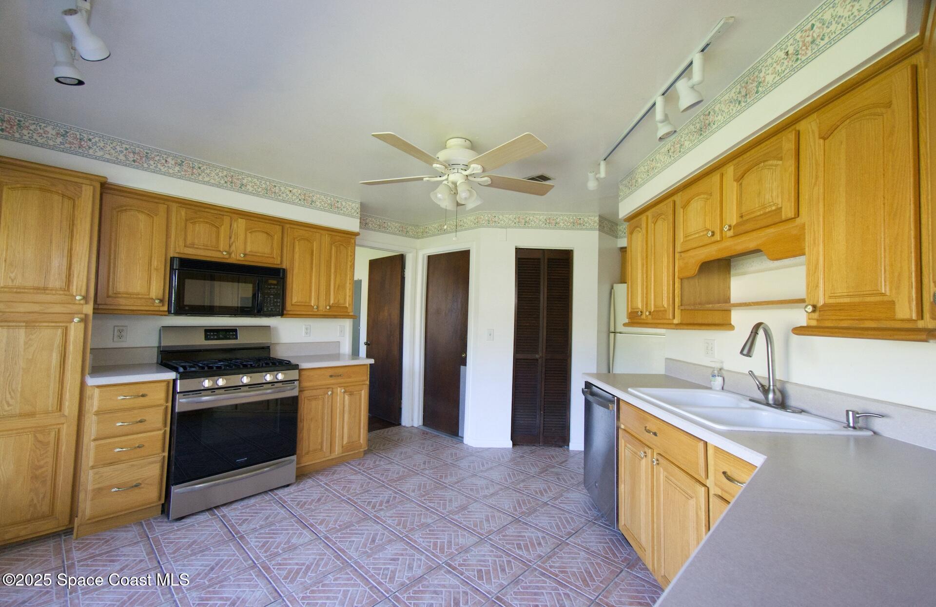1980 Talloak Road Melbourne, FL 32935 - Photo 11 of 13 a kitchen with stainless steel appliances granite countertop a sink and a stove