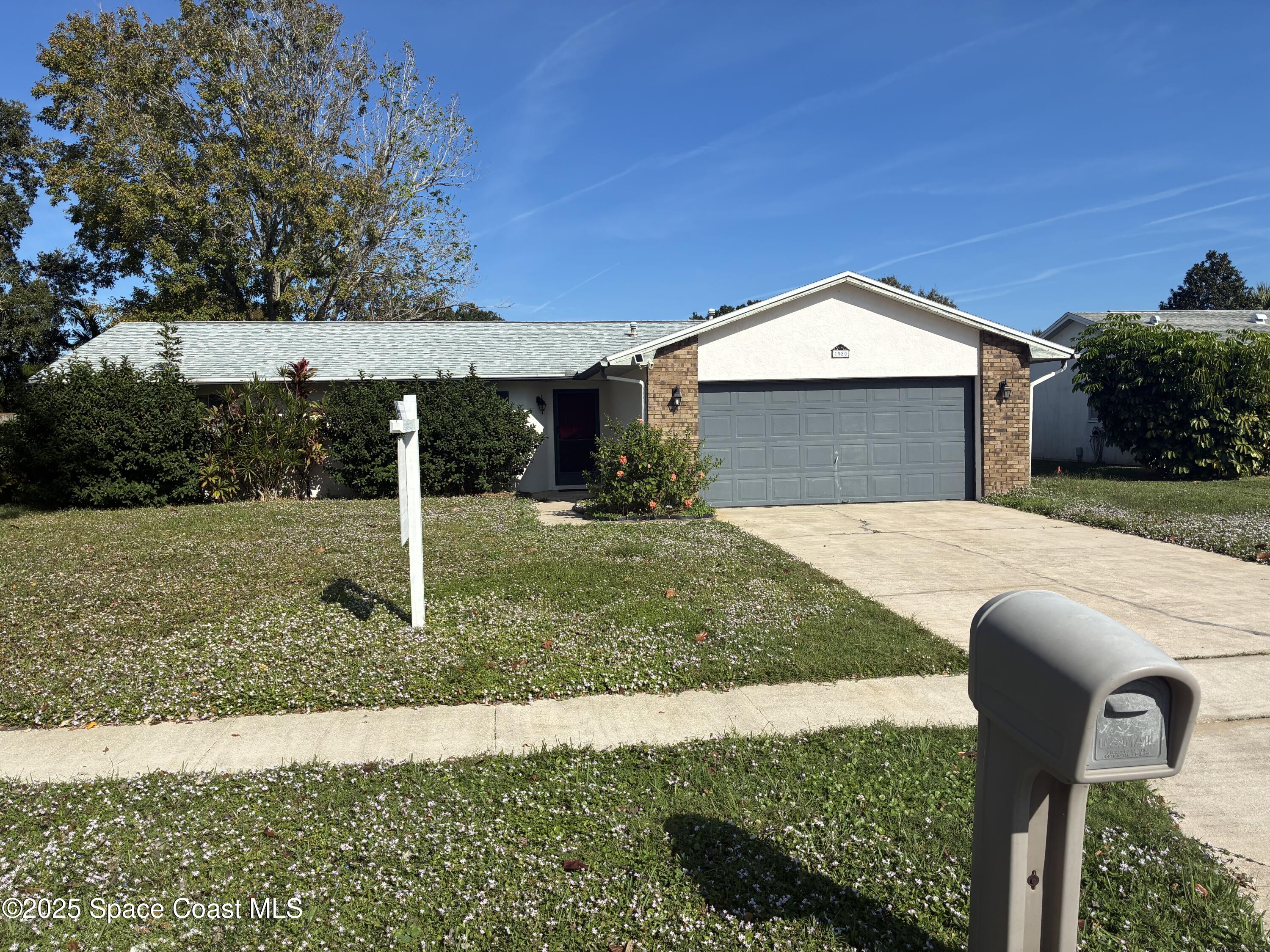 1980 Talloak Road Melbourne, FL 32935 - Photo 2 of 13 a front view of a house with garden