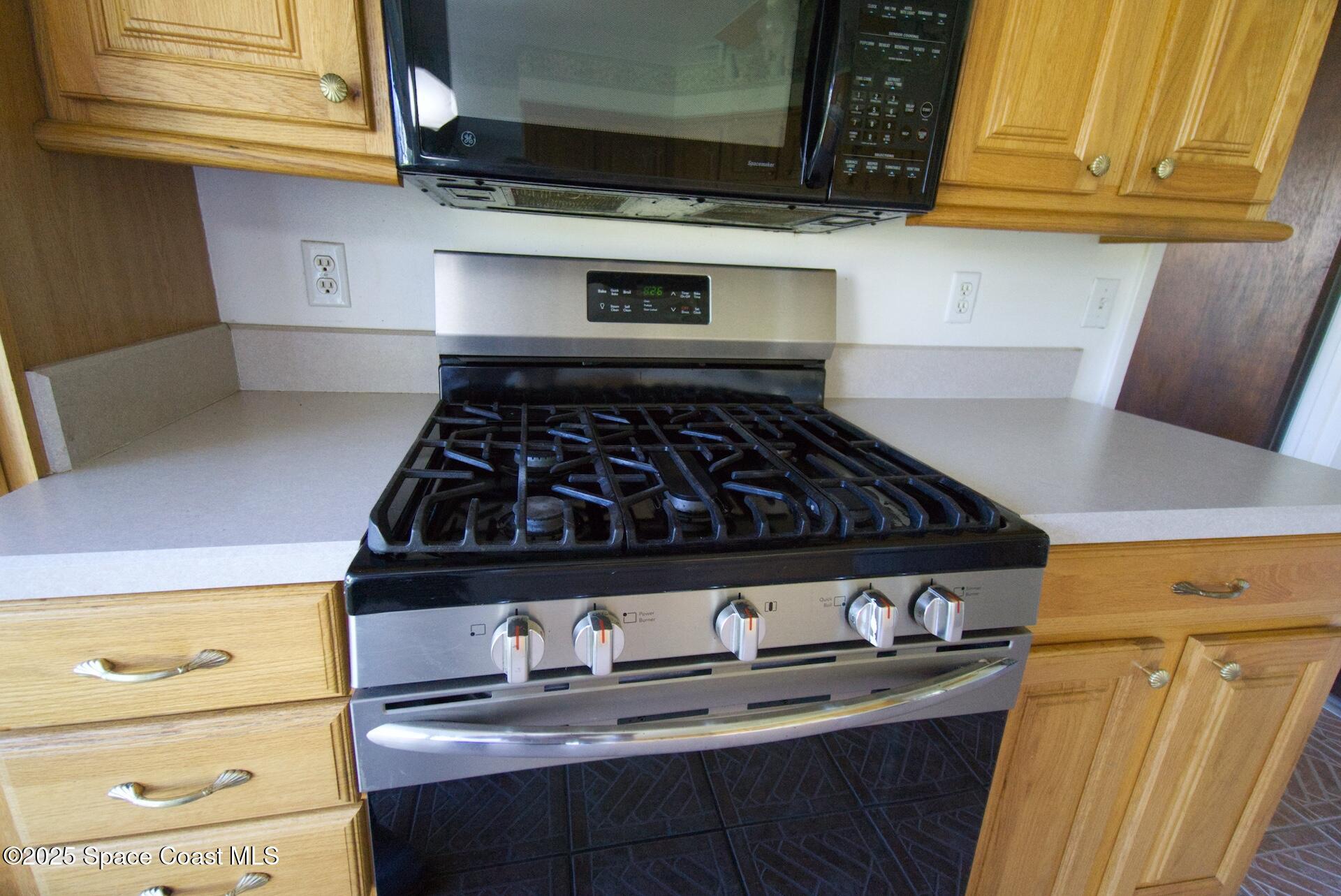 1980 Talloak Road Melbourne, FL 32935 - Photo 6 of 13 a kitchen with granite countertop a stove and cabinets