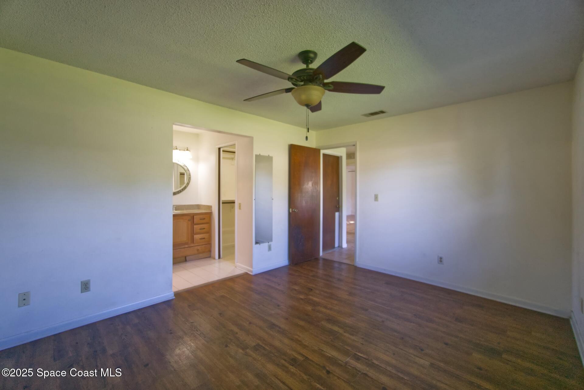 1980 Talloak Road Melbourne, FL 32935 - Photo 9 of 13 a view of a livingroom with a ceiling fan and wooden floor