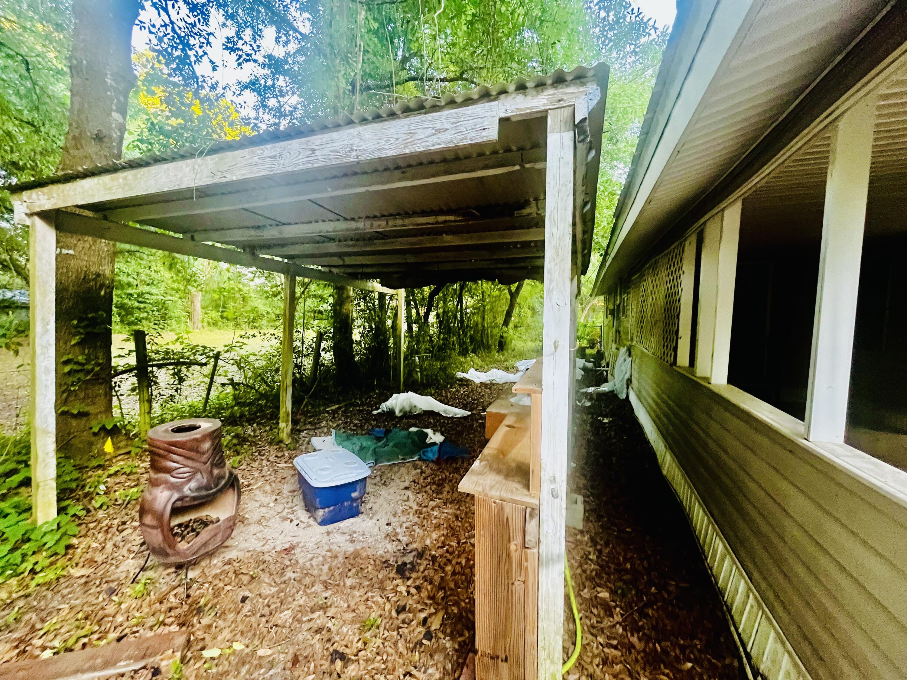 3040 Register Lane Crestview, FL 32539 - Photo 5 of 13 a view of a patio with table and chairs potted plants with floor to ceiling window and wooden fence