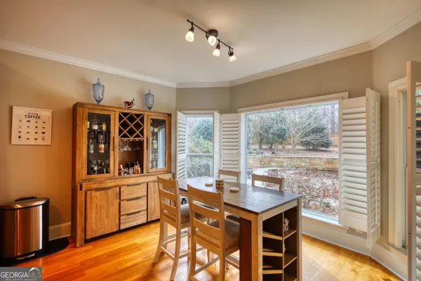 a kitchen that has a sink a table and chairs in it