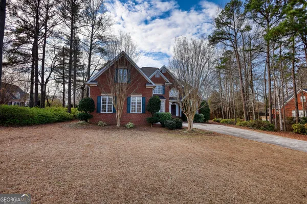 a view of a house with a large tree in front of it