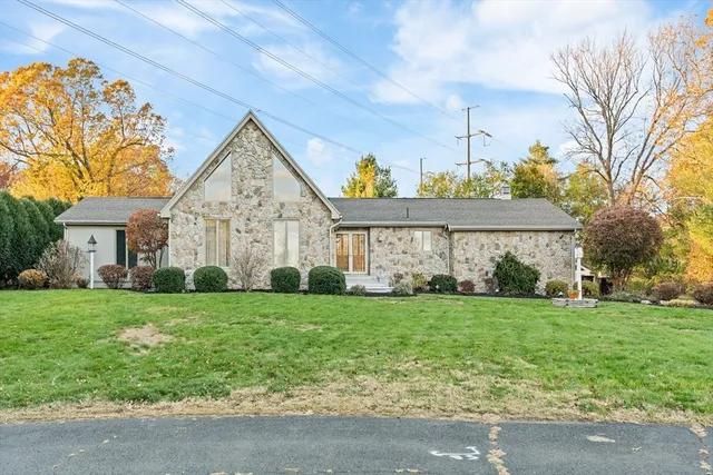a view of a big house with a big yard and large trees