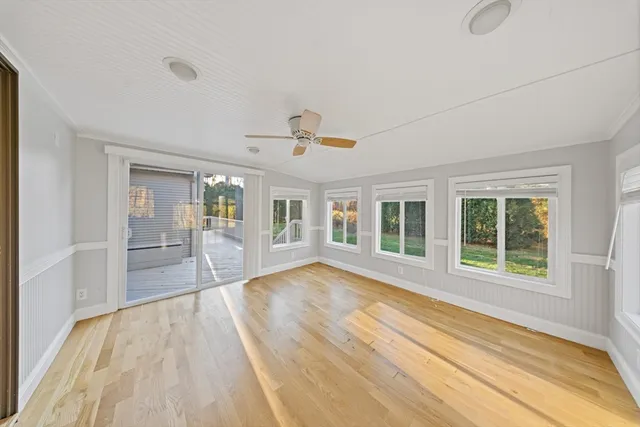a view of empty room with wooden floor and window