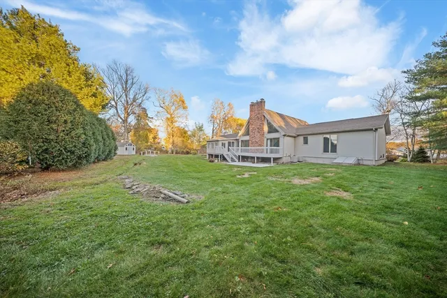 a view of a house with a big yard and large trees