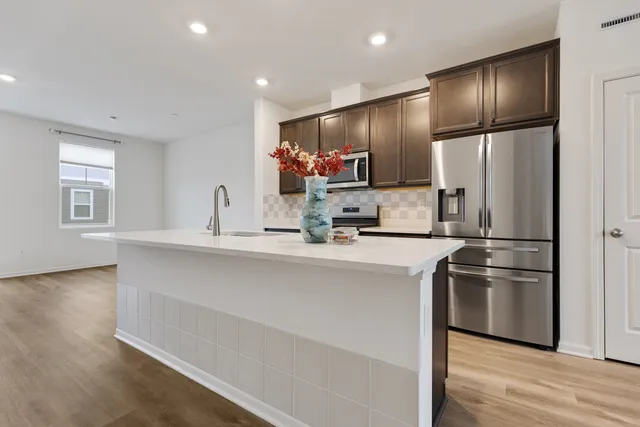 a kitchen with kitchen island white cabinets and stainless steel appliances